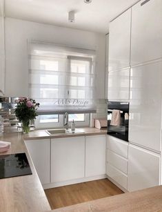 a kitchen with white cabinets and wooden floors