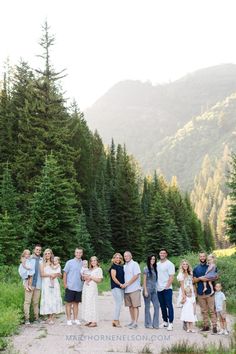 a family standing in the middle of a forest with mountains in the backgroud