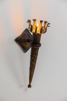 a candle holder made out of an old iron pipe with two candles on top and one light in the middle