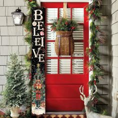 a red front door decorated with christmas decorations