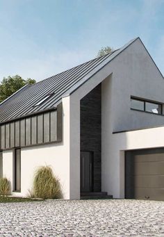 a white house with a black roof and two garages