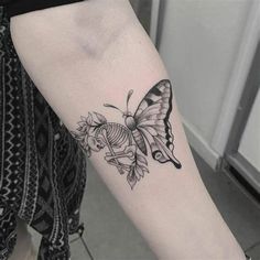 a small butterfly tattoo on the arm