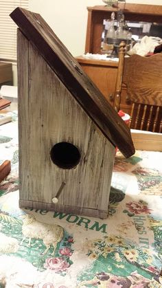 a wooden birdhouse sitting on top of a table