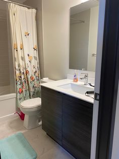 a bathroom with a toilet, sink and shower curtain