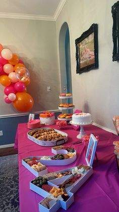 a table topped with lots of desserts and balloons