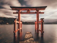 a large wooden structure sitting on top of a lake next to a green sign that says 19 places you need to visit in 2019