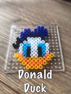 an image of a lego duck made out of plastic beads on a table with text overlay that reads, donald duck