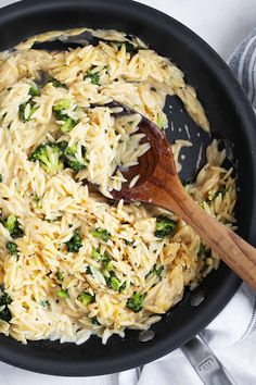 a skillet filled with pasta and broccoli on top of a white towel