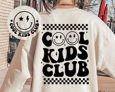 a woman wearing a white shirt with the words cool kids club in black on it