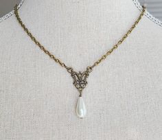 "This beautiful necklace features a beautiful brass filigree pendant with glass pearl teardrop. The necklace is reminiscent of pieces seen in classic portraits of the past. It hangs 16 1/2 \" long from a nickel free brass chain with lobster clasp and has a 2\" long extender chain with glass pearl detailing. Comes in a lovely gift box with ribbon. In the Eighteenth and Nineteenth centuries necklaces were very fashionable. Some were made of pearls, glass or gemstones and can be seen in many classic portraits. I think they're a very elegant accessory." Elegant Antique Gold Necklaces For Gift, Elegant Handmade Antique Gold Necklace, Elegant Antique Gold Necklace For Gift, Vintage Filigree Baroque Necklace, Victorian Pearl Necklace For Formal Occasions, Elegant Antique Gold Brass Necklaces, Victorian Style Formal Pearl Necklace, Wedding Filigree Teardrop Necklace, Victorian Pearl Drop Necklace For Gifts