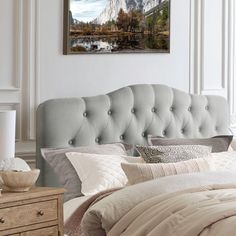 a bedroom with a bed, dresser and painting on the wall above it's headboard