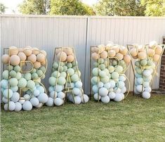 the letters are made out of balloons in front of a fence