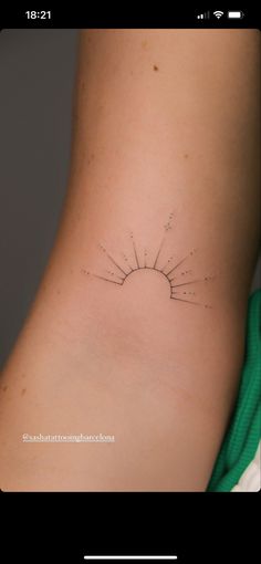 a small sun tattoo on the back of a woman's neck