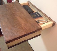 a wooden table with some books and other items in the drawer on top of it