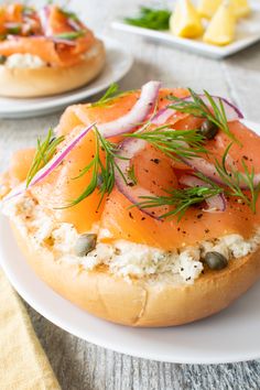 a bagel with smoked salmon and capers on it sitting on a white plate