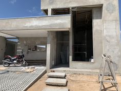 a motorcycle is parked in front of a building under construction with concrete steps leading up to it