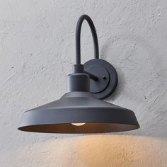 a light that is on the wall next to a white wall with a black lamp