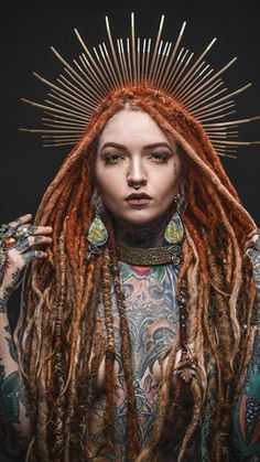 a woman with dreadlocks and piercings on her head is posing for the camera