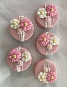 four pink and white flowers are on top of each other in the shape of buttons