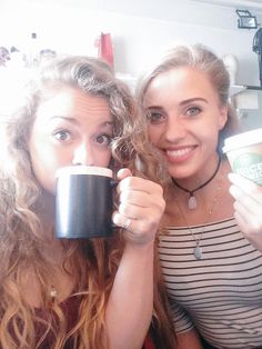 two women holding coffee cups in their hands