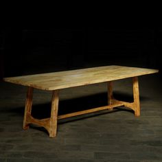 a wooden table sitting on top of a stone floor in the dark with no one around it