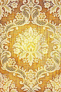 an ornate yellow and white pattern on fabric