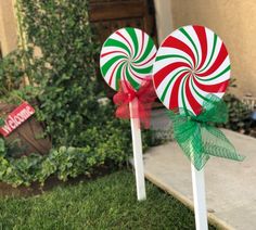 two candy lollipops sitting on top of each other in front of a house