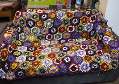 a crocheted couch sitting on top of a wooden table