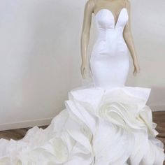 a white wedding dress on display in a room