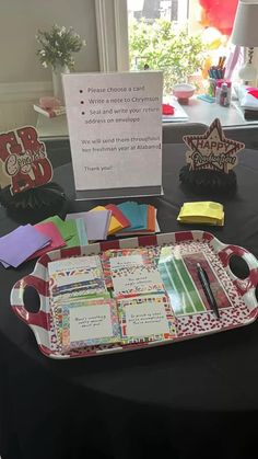 there is a tray on the table that has cards and pens in it for someone to write