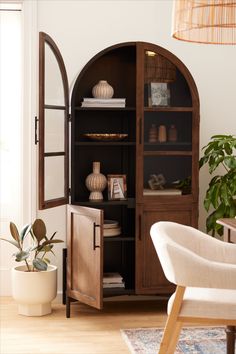 an arch - shaped bookcase in the corner of a room with a chair and potted plant