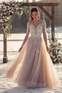 a woman standing in the snow wearing a wedding dress