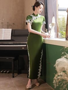 Fall in love with a long green qipao dress and its classy design. Made in a vibrant green color, this Chinese dress looks both elegant and refreshing. The satin fabric, carefully selected for its softness and comfort, adds a touch of sophistication to the long qipao dress. Fitted Dark Green Floor-length Dress, Dark Green Fitted Floor-length Dress, Green Short Sleeve Dress For Wedding, Green Spring Evening Dress For Banquet, Elegant Green Midi Dress With Short Sleeves, Long Dresses For Tea Ceremony, Elegant Dark Green Maxi Dress For Spring, Fitted Green Maxi Evening Dress, Fitted Green Maxi Length Evening Dress