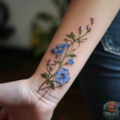 a small blue flower tattoo on the wrist