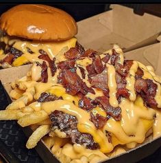 a cheeseburger with bacon and fries in a box