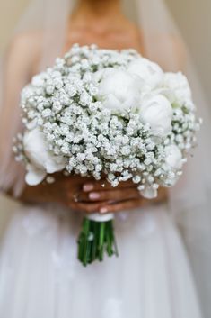 a bridal holding a bouquet of white flowers