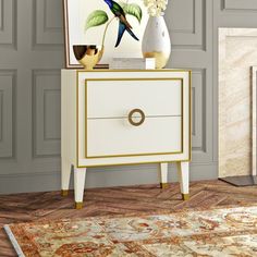 a white and gold chest of drawers in a living room with flowers on the top