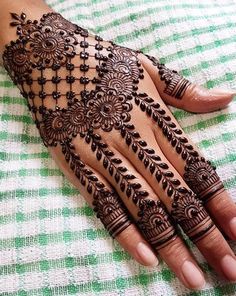 a woman's hand with henna tattoos on it