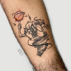 a man with a tattoo on his arm holding a basketball in one hand and an orange ball in the other