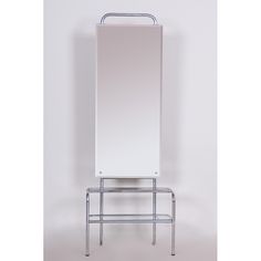 a white mirror sitting on top of a metal shelf