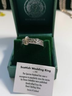 a wedding ring in a green box with a card on the inside that says scottish wedding ring