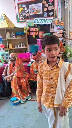 a young boy standing in front of an assortment of children's clothing and toys