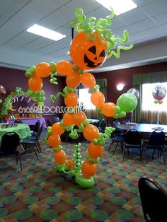 an orange and green balloon decoration in the shape of a pumpkin