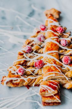 a pastry decorated with icing and cranberries on top of a white table