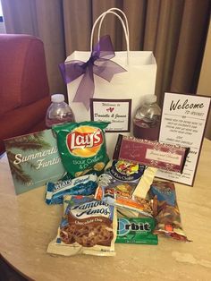 a table topped with lots of food and drinks next to a bag filled with candy