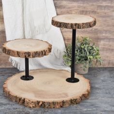 two tiered wooden trays with black metal legs and wood slices on the sides