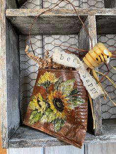 an old wooden box with a bee and sunflower decoration on it's side