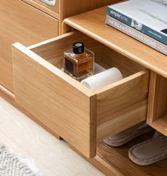 an open drawer with some items in it and someone's shoes on the floor