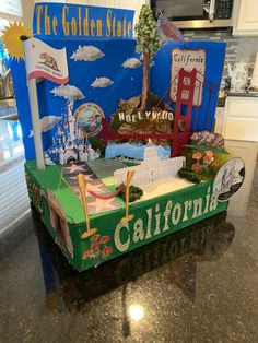 a cardboard california sign sitting on top of a counter next to a blue box with the golden gate