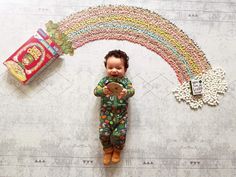 a baby doll laying on top of a floor next to a candy bar and rainbow